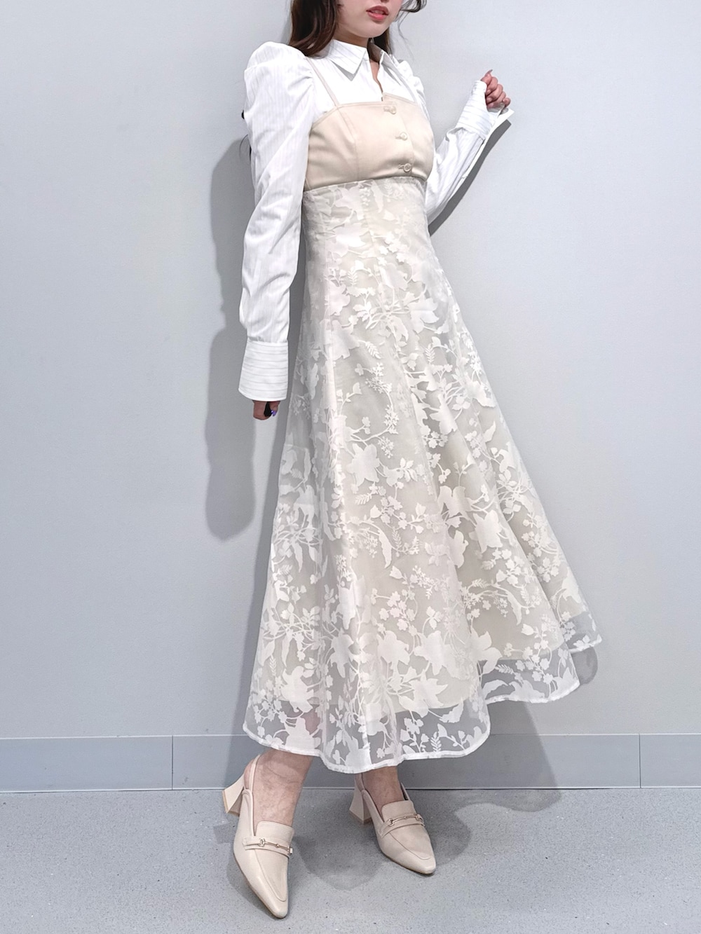 ベージュ系のワンピース、ホワイト系のパンプスを着用したレディースの冬コーディネートの8枚目の写真