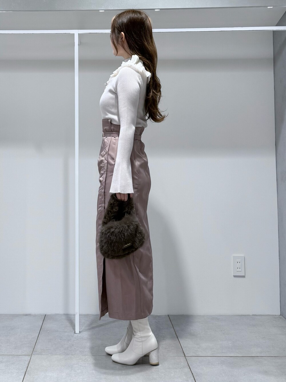 ホワイト系のニット/セーター、ブラウン系のハンドバッグ、ピンク系のスカートを着用したレディースの秋コーディネートの3枚目の写真
