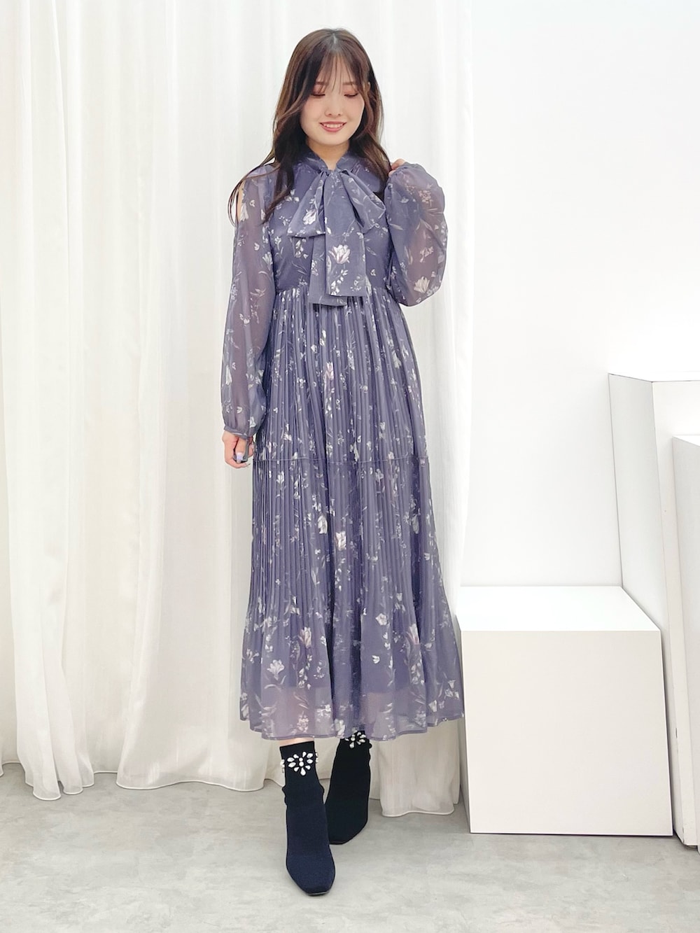 グレー系のワンピース、ブラック系のブーツ、グレー系のテーラードジャケットを着用したレディースの秋コーディネートの6枚目の写真