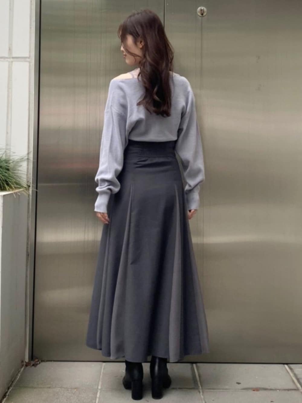 ホワイト系のダウンジャケット/コート、ブルー系のニット/セーター、グレー系のスカートを着用したレディースの秋コーディネートの7枚目の写真