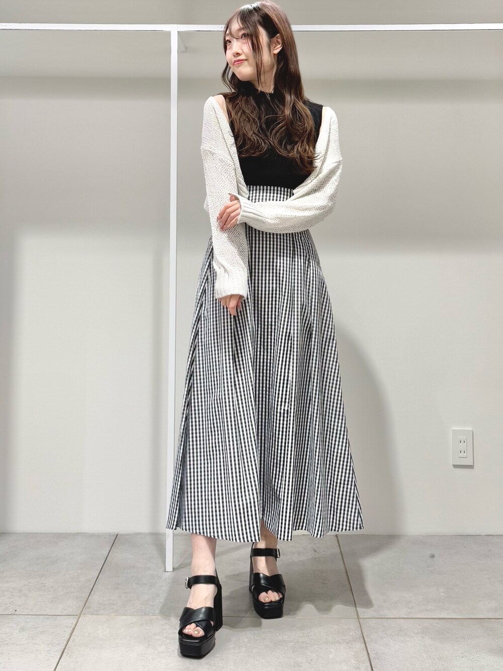 ブラック系のサンダル、その他のスカート、ブラック系のニット/セーターを着用したレディースの春コーディネートの2枚目の写真