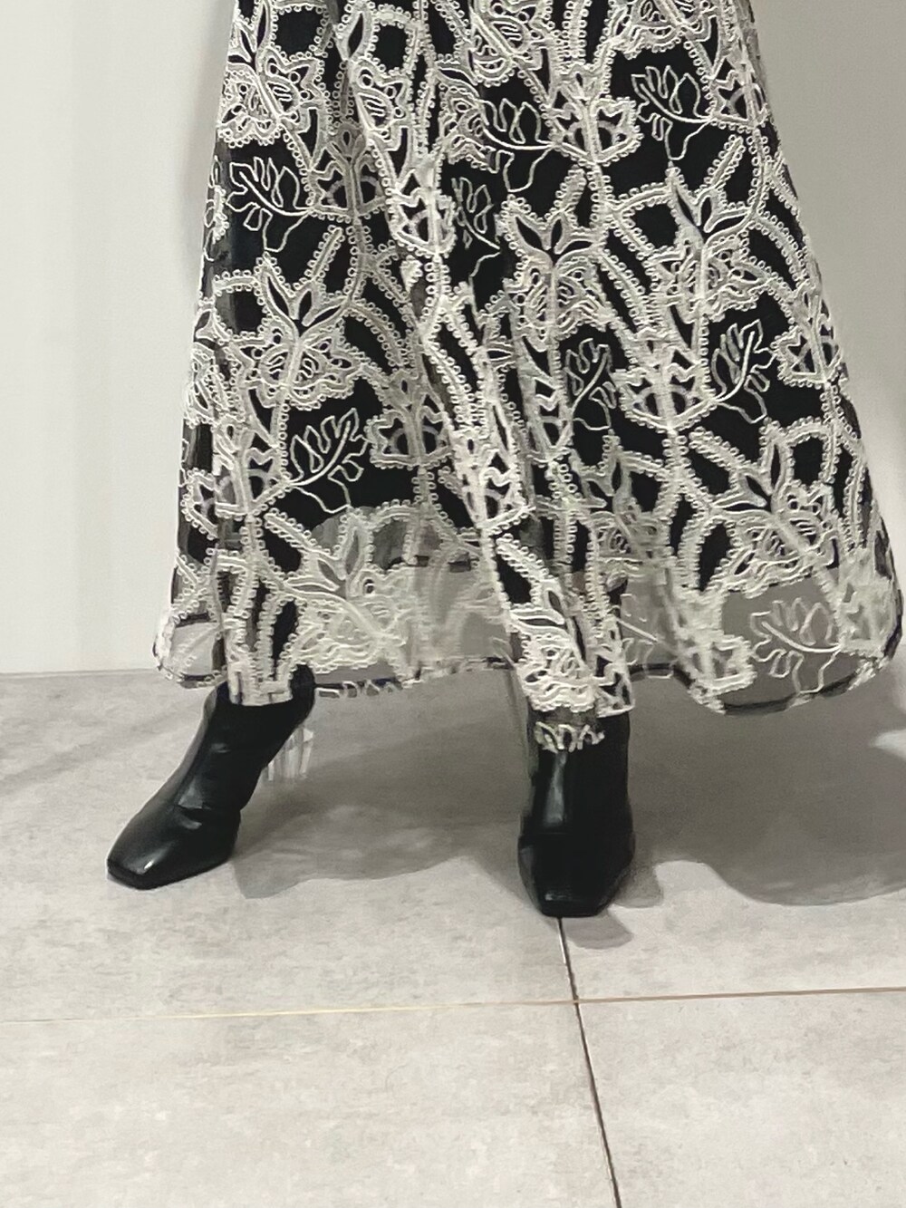 グレー系のカーディガン/ボレロ、ブラック系のスカート、ブラック系のブーツを着用したレディースの冬コーディネートの7枚目の写真