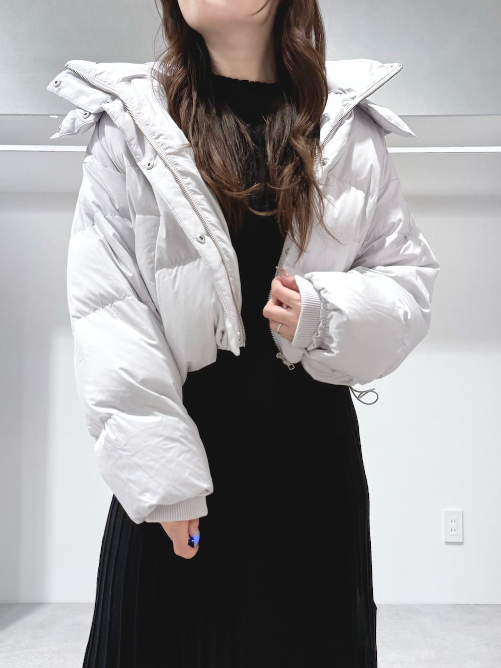 ブラック系のワンピース、ホワイト系のハンドバッグ、ブラック系のブーツを着用したレディースの秋コーディネートの5枚目の写真