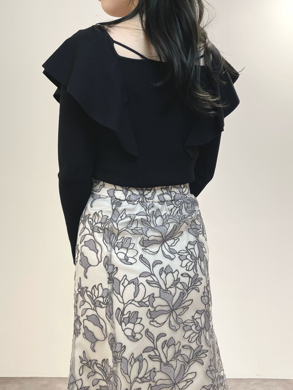 グレー系のスカート、ブラウン系のブーツ、ブラック系のダウンジャケット/コートを着用したレディースの冬コーディネートの10枚目の写真