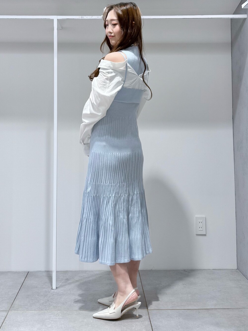 ブルー系のワンピース、ホワイト系のパンプスを着用したレディースの冬コーディネートの2枚目の写真