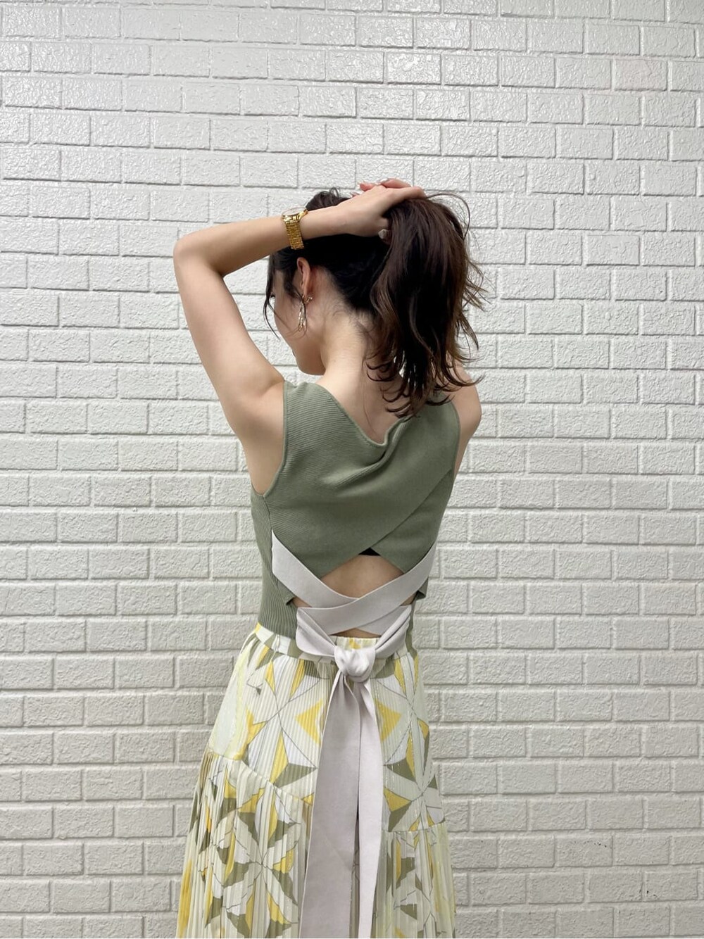 ベージュ系のサンダル、イエロー系のスカート、ベージュ系のニット/セーターを着用したレディースの夏コーディネートの7枚目の写真