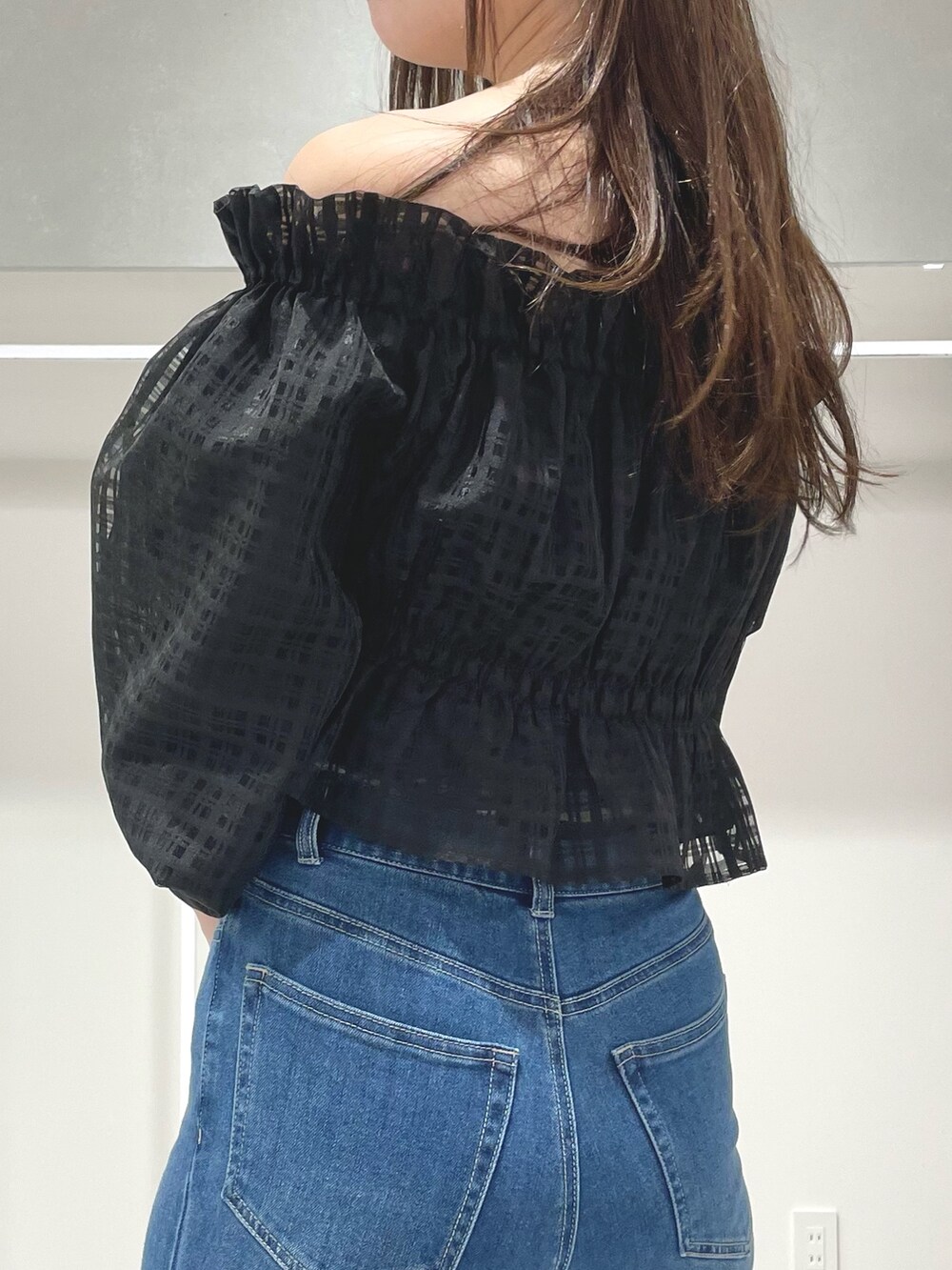 ブルー系のトレンチコート、ブルー系のデニムパンツ、ブラック系のブーツを着用したレディースの春コーディネートの9枚目の写真