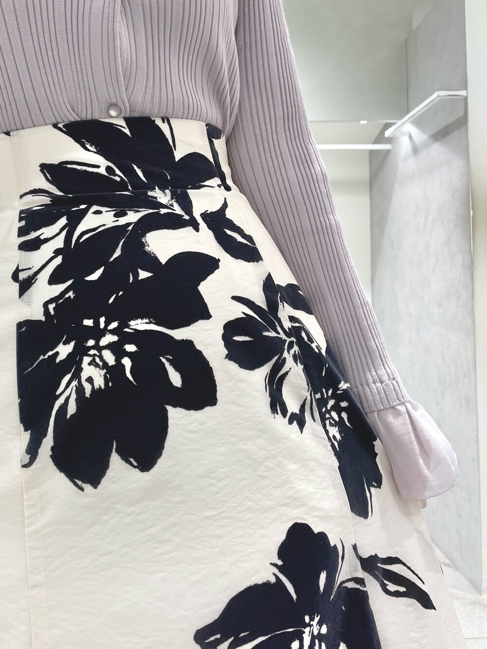 ホワイト系のスカート、ホワイト系のチェスターコート、ベージュ系のカーディガン/ボレロを着用したレディースの秋コーディネートの7枚目の写真