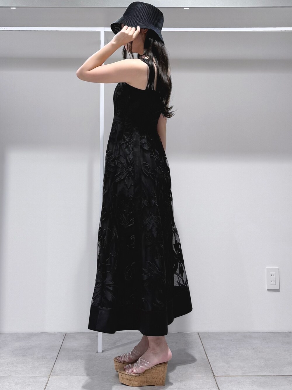 ブラック系のワンピース、その他のサンダル、ブラック系のハットを着用したレディースの夏コーディネートの3枚目の写真