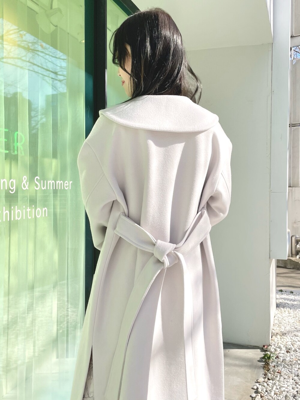 シルバー系のハンドバッグ、ホワイト系のブーツ、ホワイト系のチェスターコートを着用したレディースの冬コーディネートの4枚目の写真