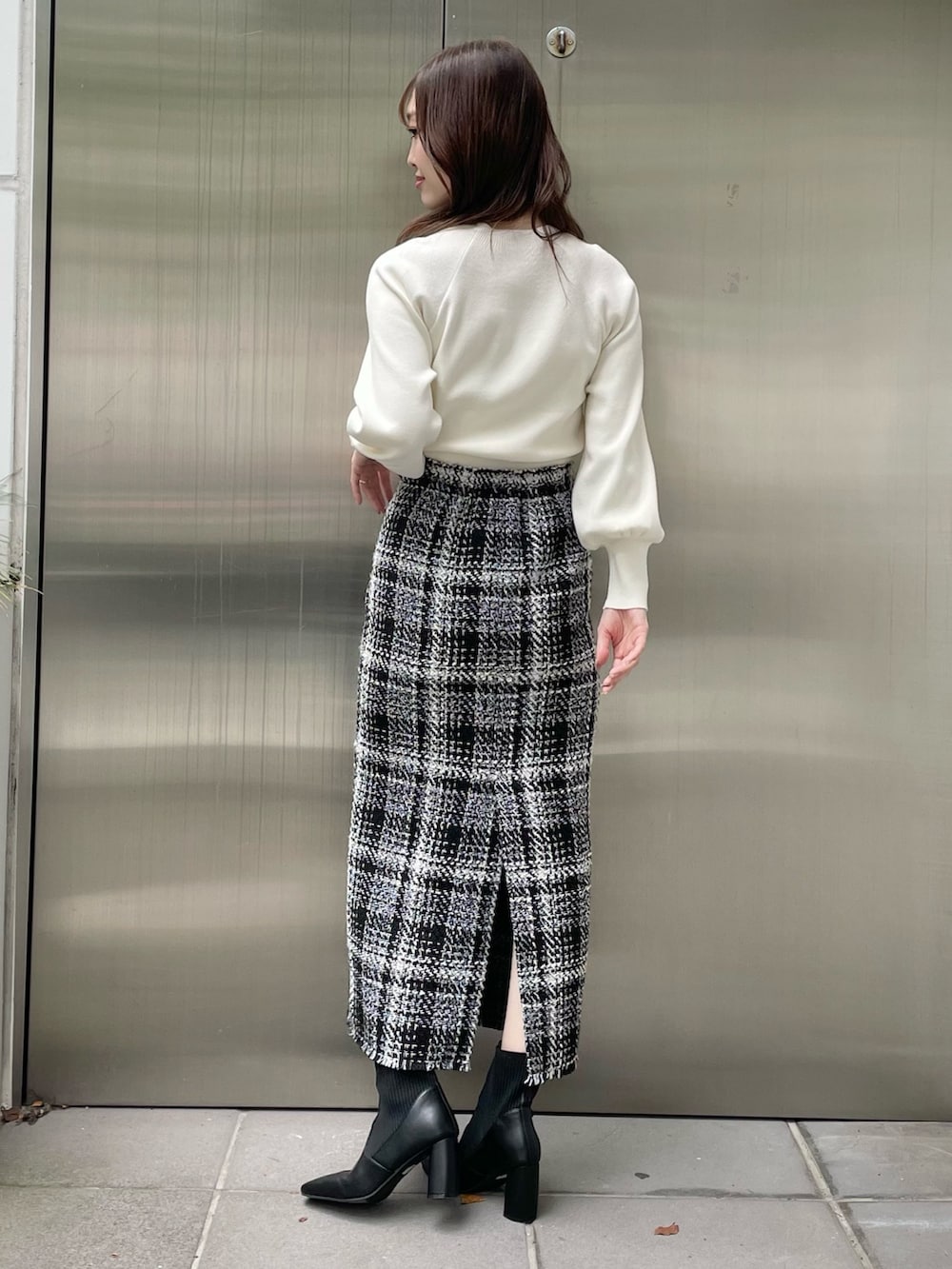 グリーン系のカーディガン/ボレロ、ブラック系のスカート、ブラック系のブーツを着用したレディースの秋コーディネートの7枚目の写真