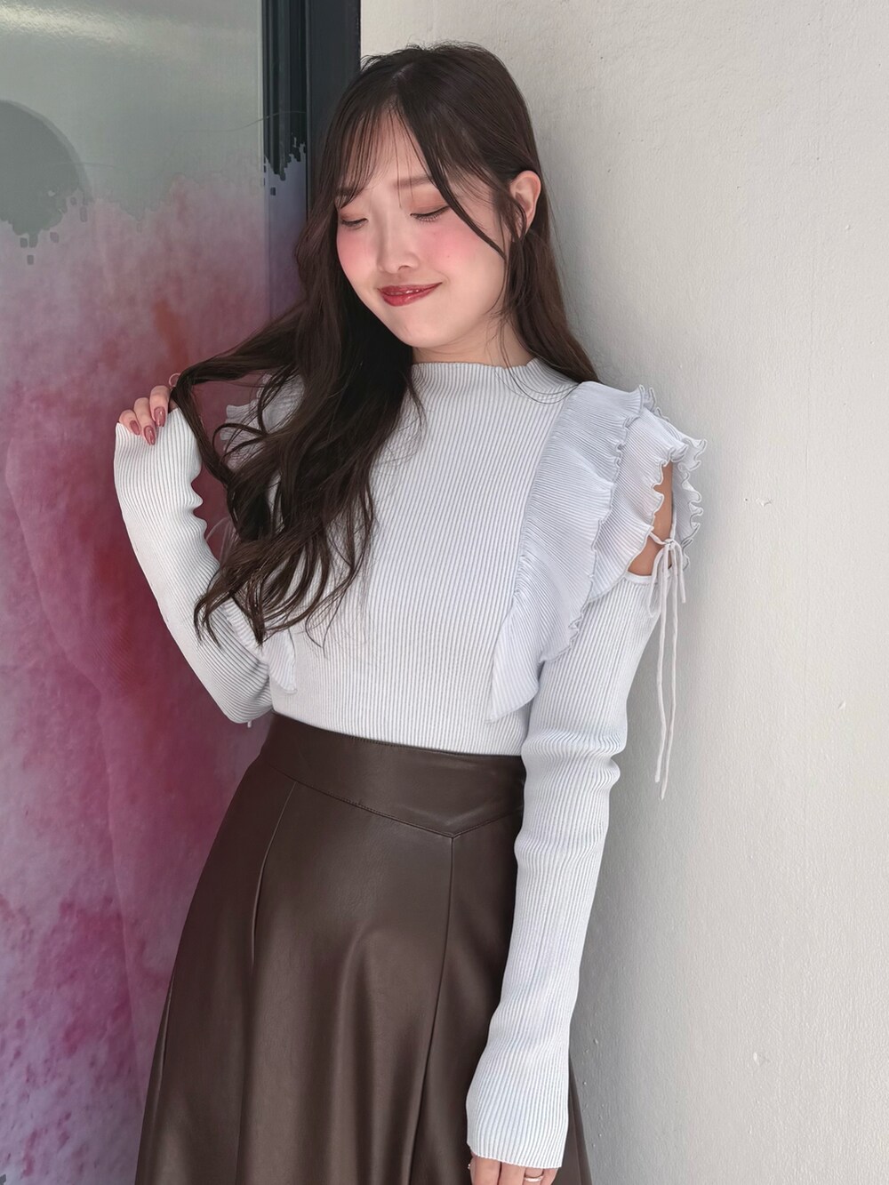 ブラウン系のスカート、ブルー系のニット/セーター、ブラック系のブーツを着用したレディースの秋コーディネートの5枚目の写真