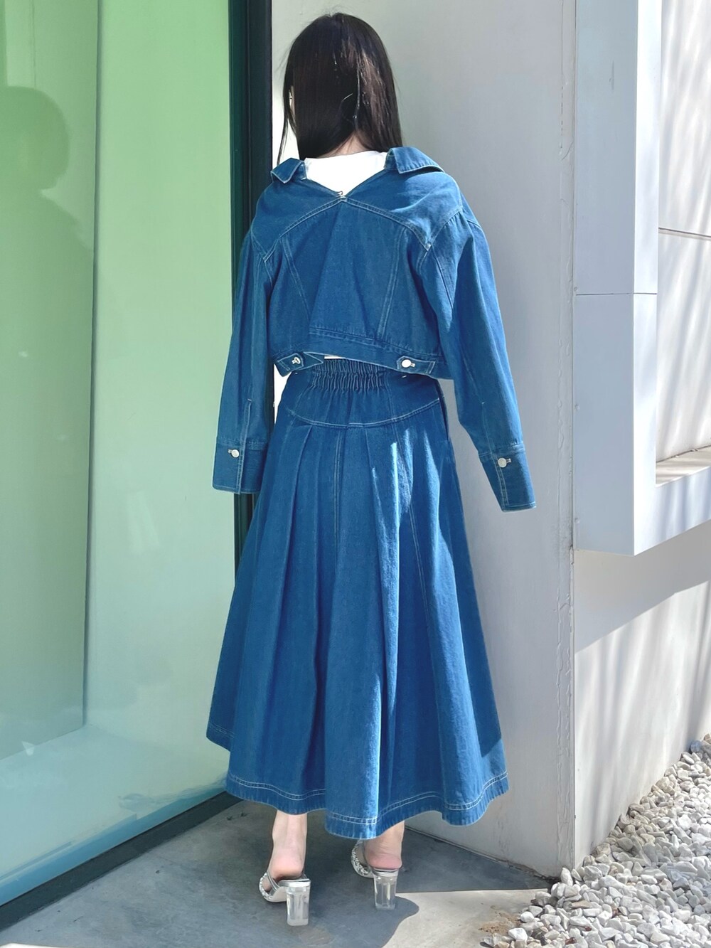 ブルー系のスカート、シルバー系のハンドバッグ、シルバー系のパンプスを着用したレディースの春コーディネートの3枚目の写真