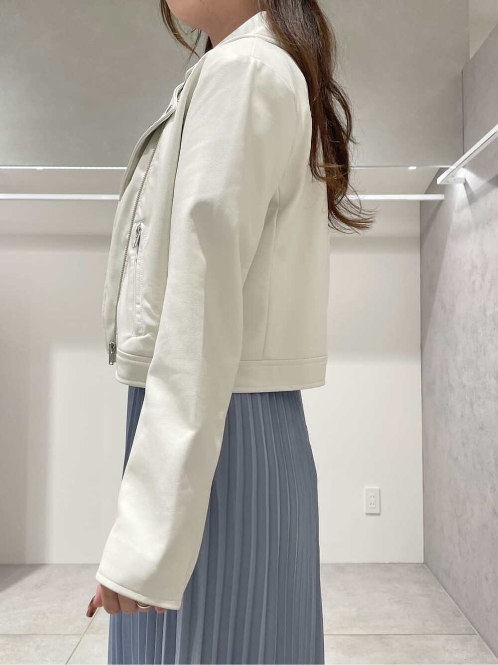 ホワイト系のブーツ、ホワイト系のライダースジャケット、ブルー系のワンピースを着用したレディースの秋コーディネートの6枚目の写真