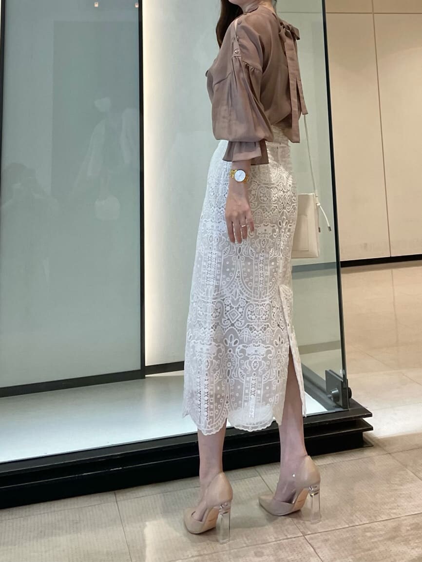 ピンク系のシャツ/ブラウス、ホワイト系のスカート、ベージュ系のパンプスを着用したレディースの夏コーディネートの2枚目の写真