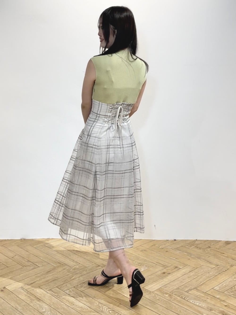 グリーン系のワンピース、ブラック系のサンダルを着用したレディースの春コーディネートの3枚目の写真