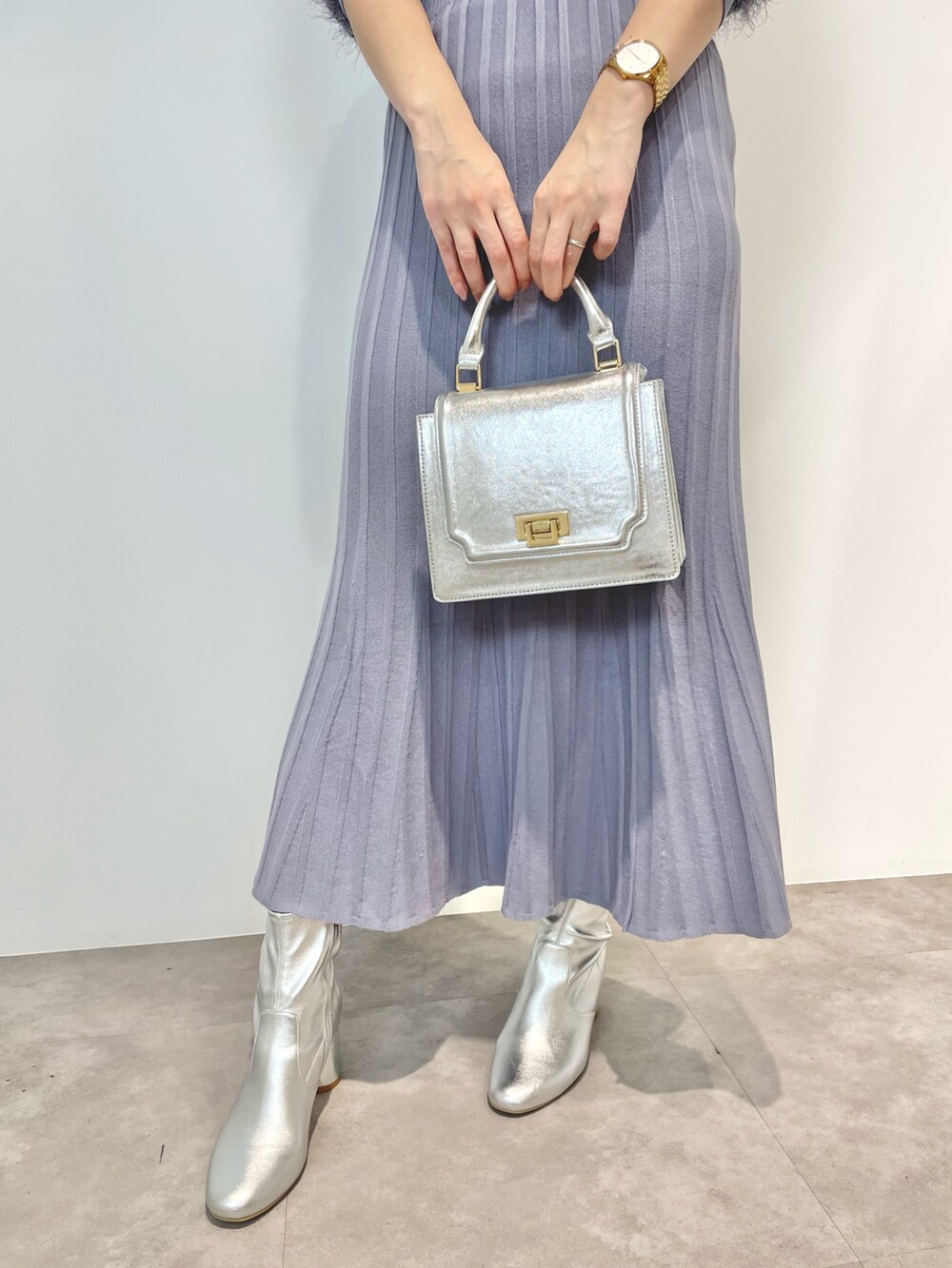 ブルー系のワンピース、シルバー系のハンドバッグ、シルバー系のブーツを着用したレディースの冬コーディネートの6枚目の写真