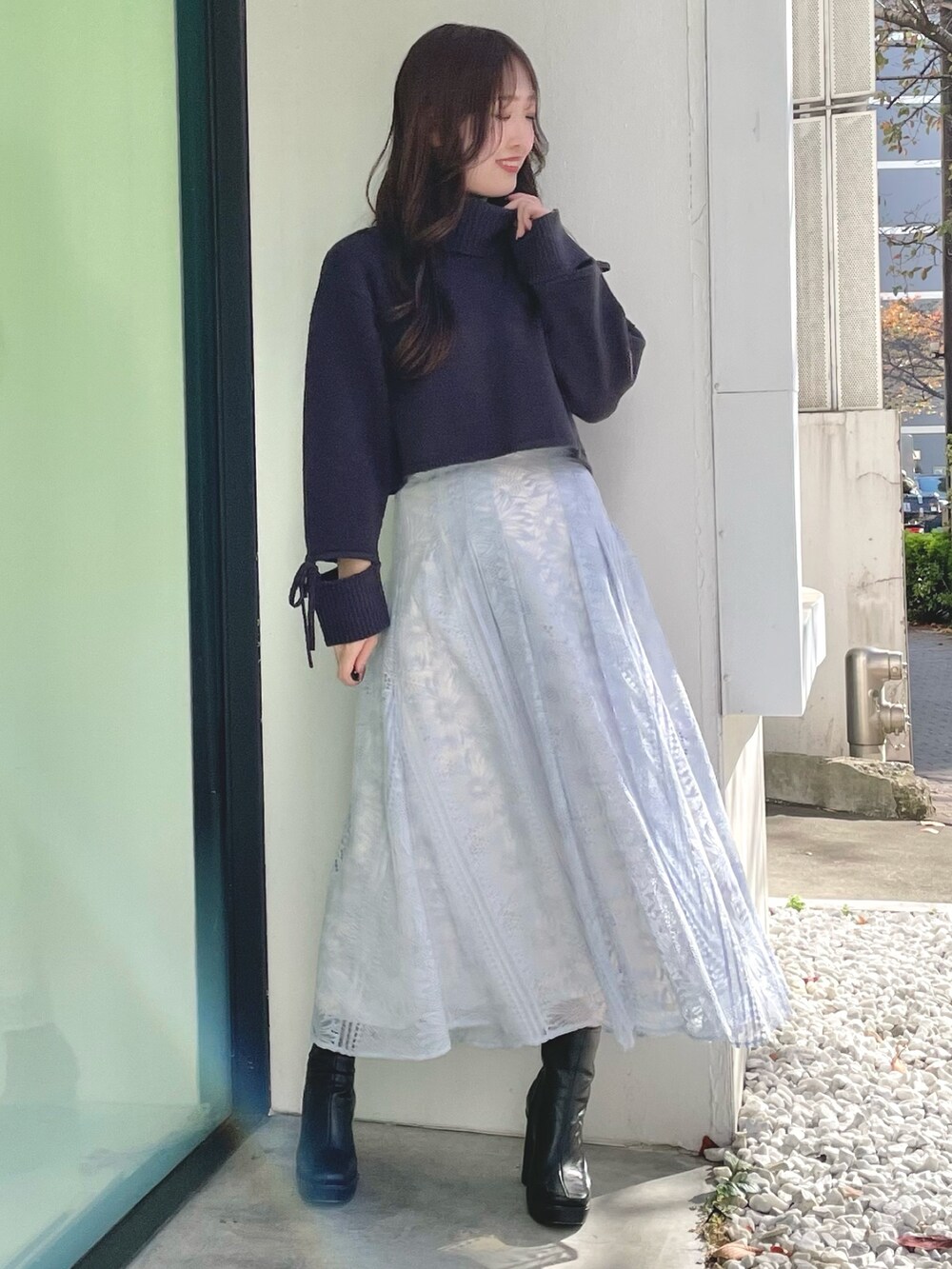 ブルー系のスカート、グレー系のニット/セーター、ブラック系のブーツを着用したレディースの冬コーディネートの2枚目の写真