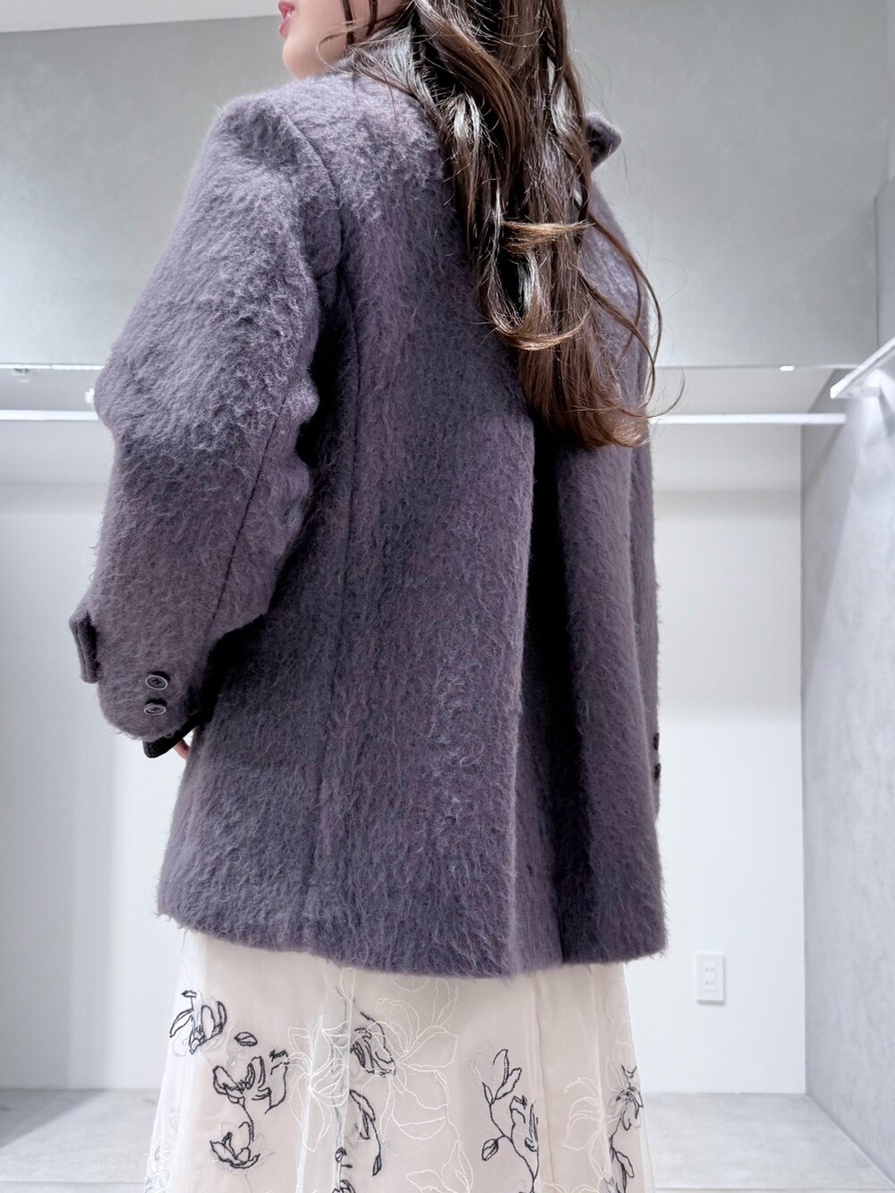 グレー系のその他アウター、グレー系のニット/セーター、ホワイト系のスカートを着用したレディースの冬コーディネートの6枚目の写真