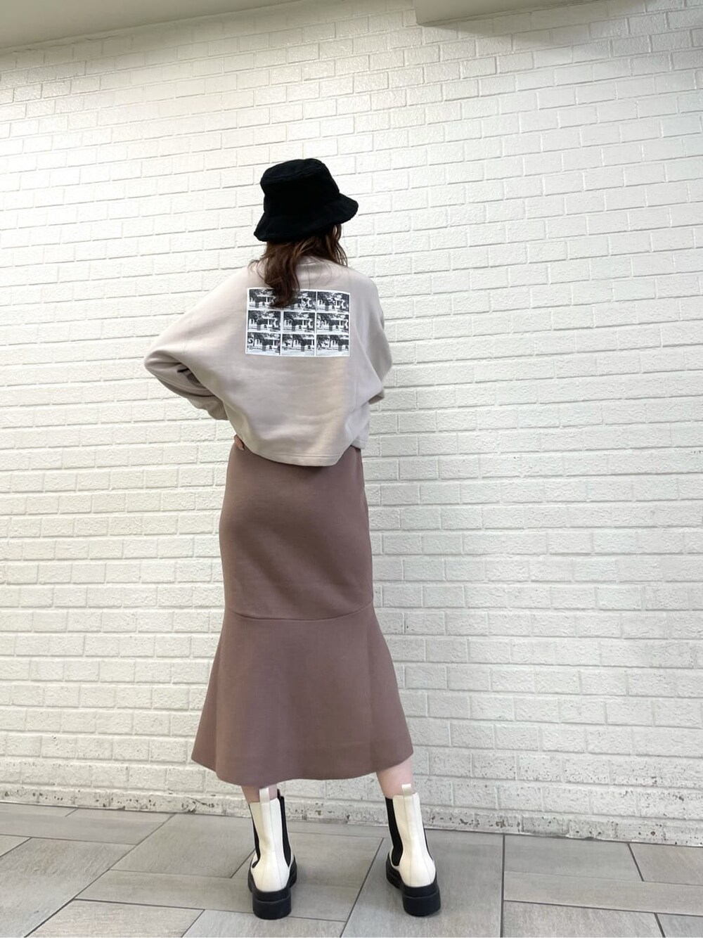 ベージュ系のTシャツ/カットソー、ブラウン系のワンピース、ホワイト系のブーツを着用したレディースの秋コーディネートの3枚目の写真