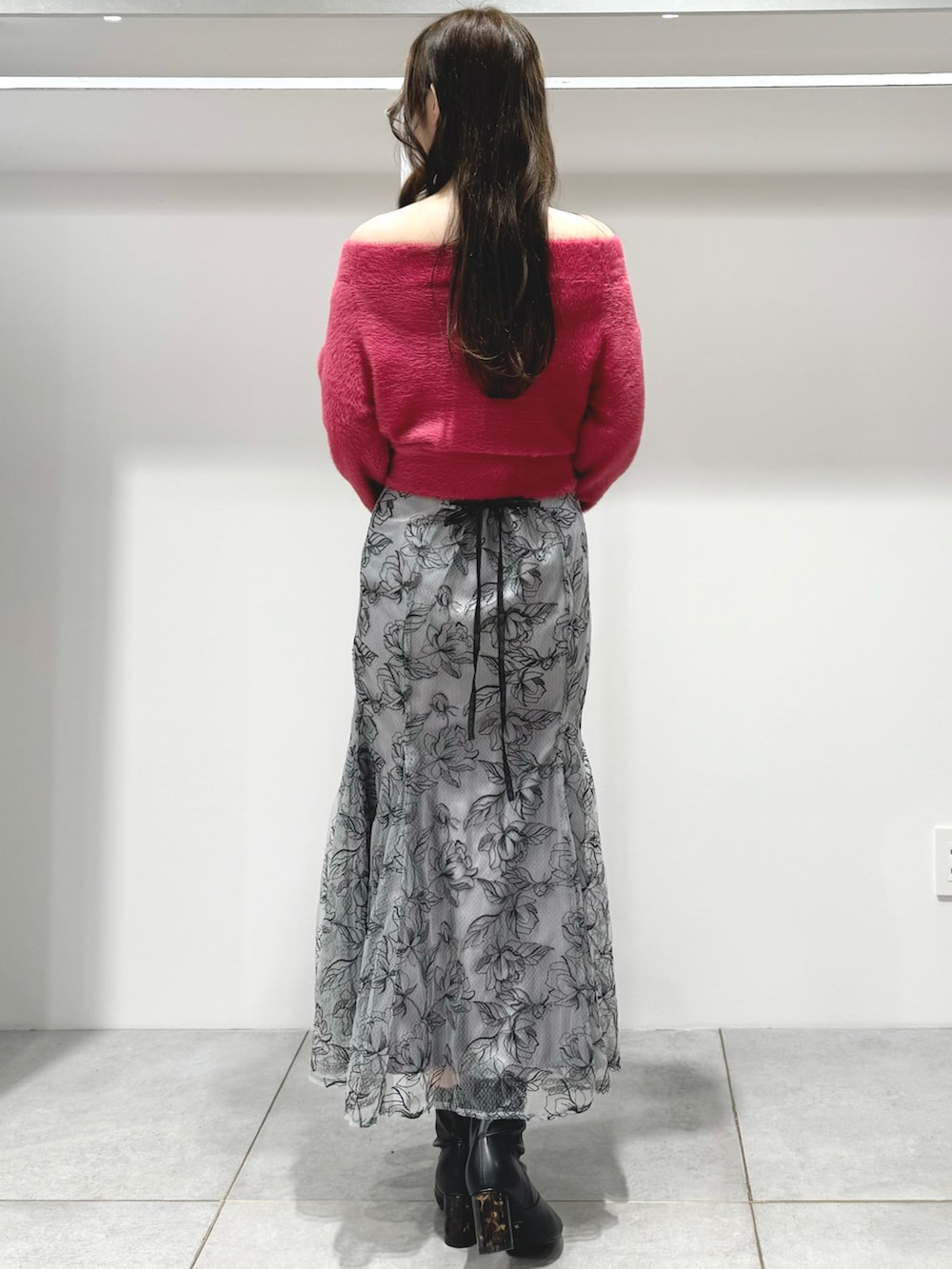 レッド系のニット/セーター、グレー系のハンドバッグ、グレー系のスカートを着用したレディースの秋コーディネートの4枚目の写真