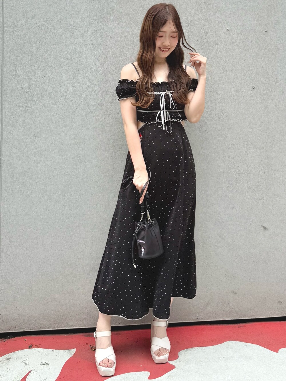 ブラック系のワンピース、ブラック系のショルダーバッグ、ホワイト系のサンダルを着用したレディースの春コーディネートの3枚目の写真