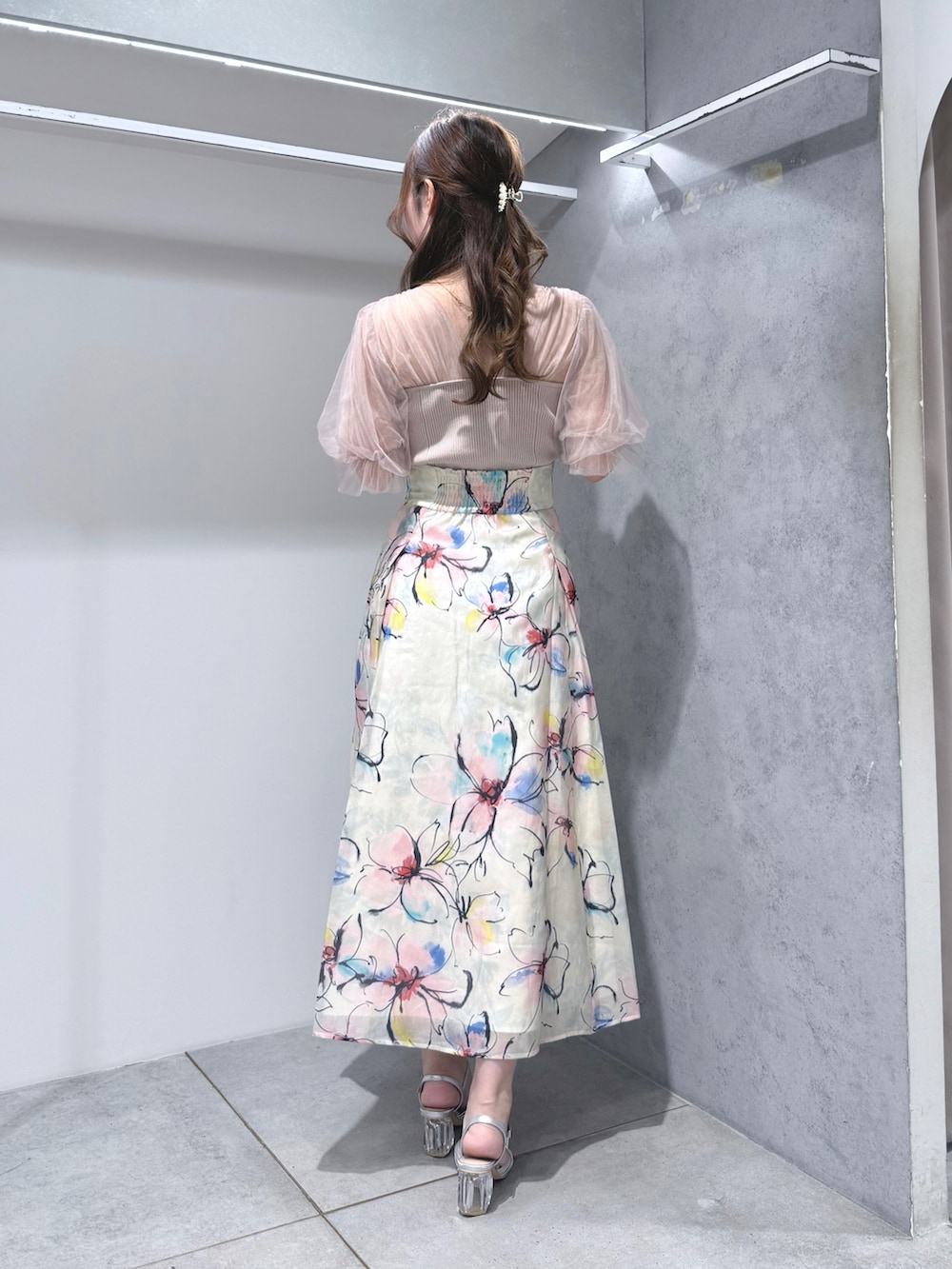 ピンク系のニット/セーター、ホワイト系のスカート、シルバー系のサンダルを着用したレディースの夏コーディネートの3枚目の写真