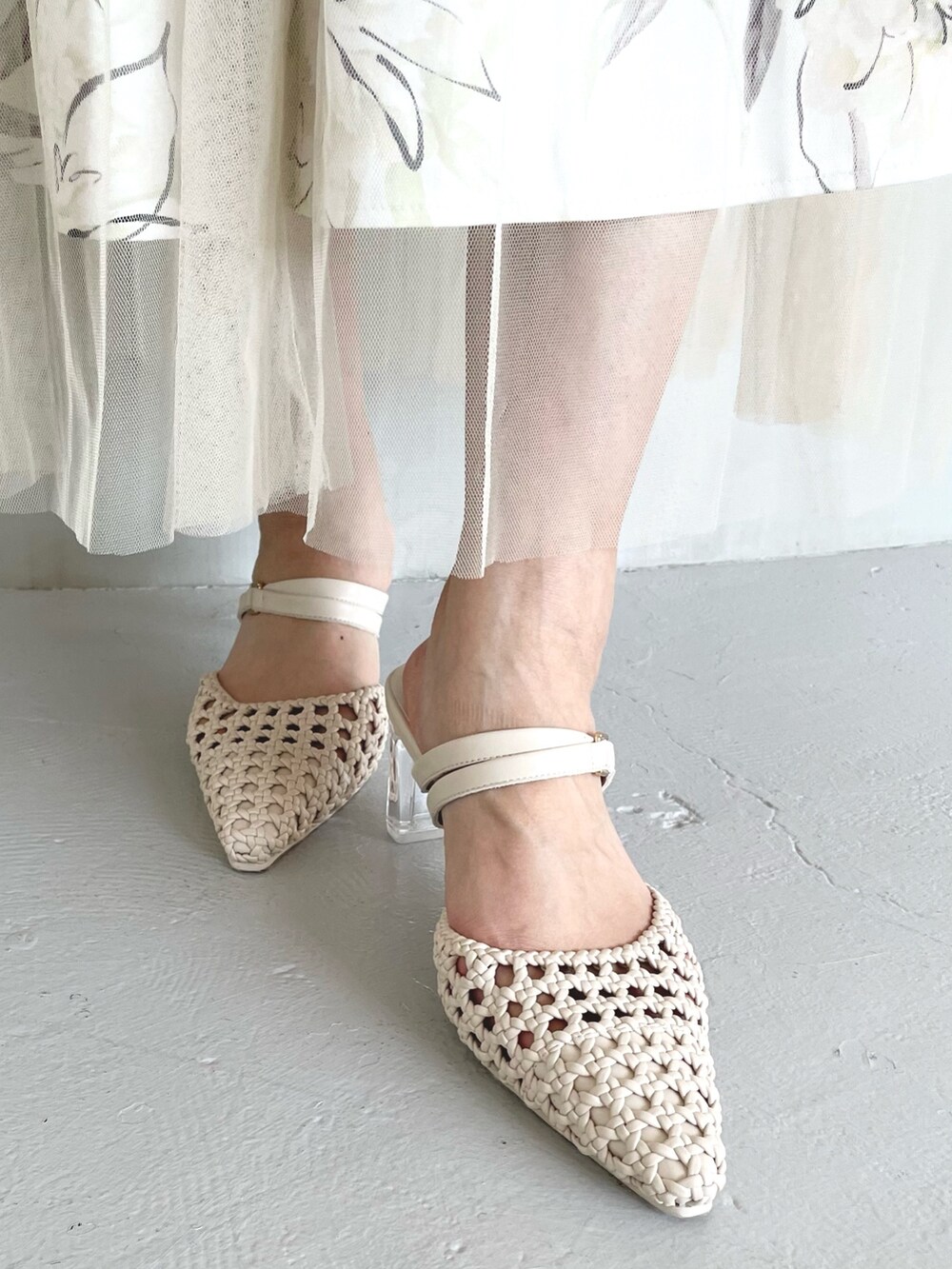 グリーン系のニット/セーター、イエロー系のスカート、ホワイト系のパンプスを着用したレディースの春コーディネートの7枚目の写真