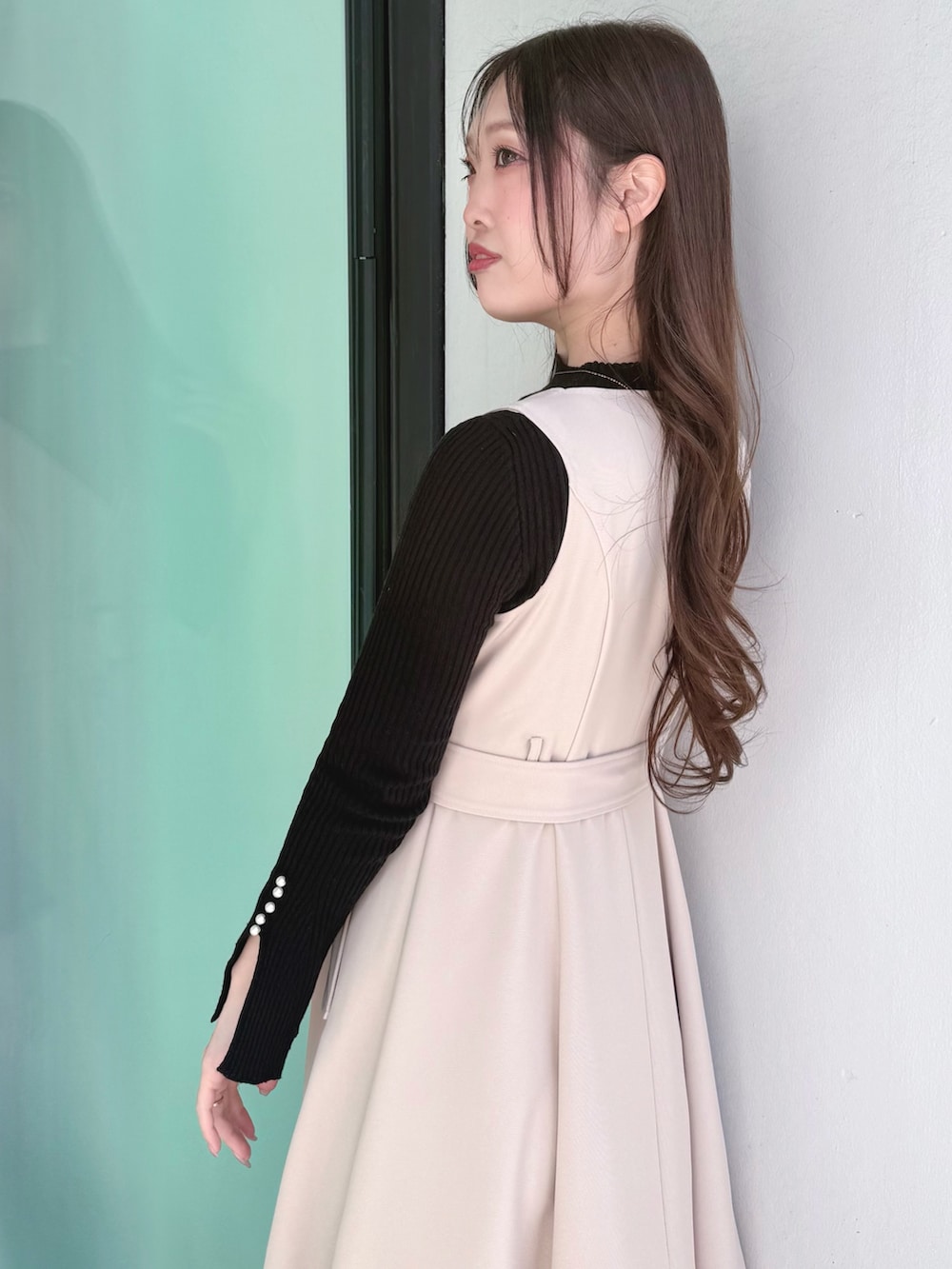 ベージュ系のワンピース、ベージュ系のブーツ、ベージュ系のトレンチコートを着用したレディースの冬コーディネートの9枚目の写真