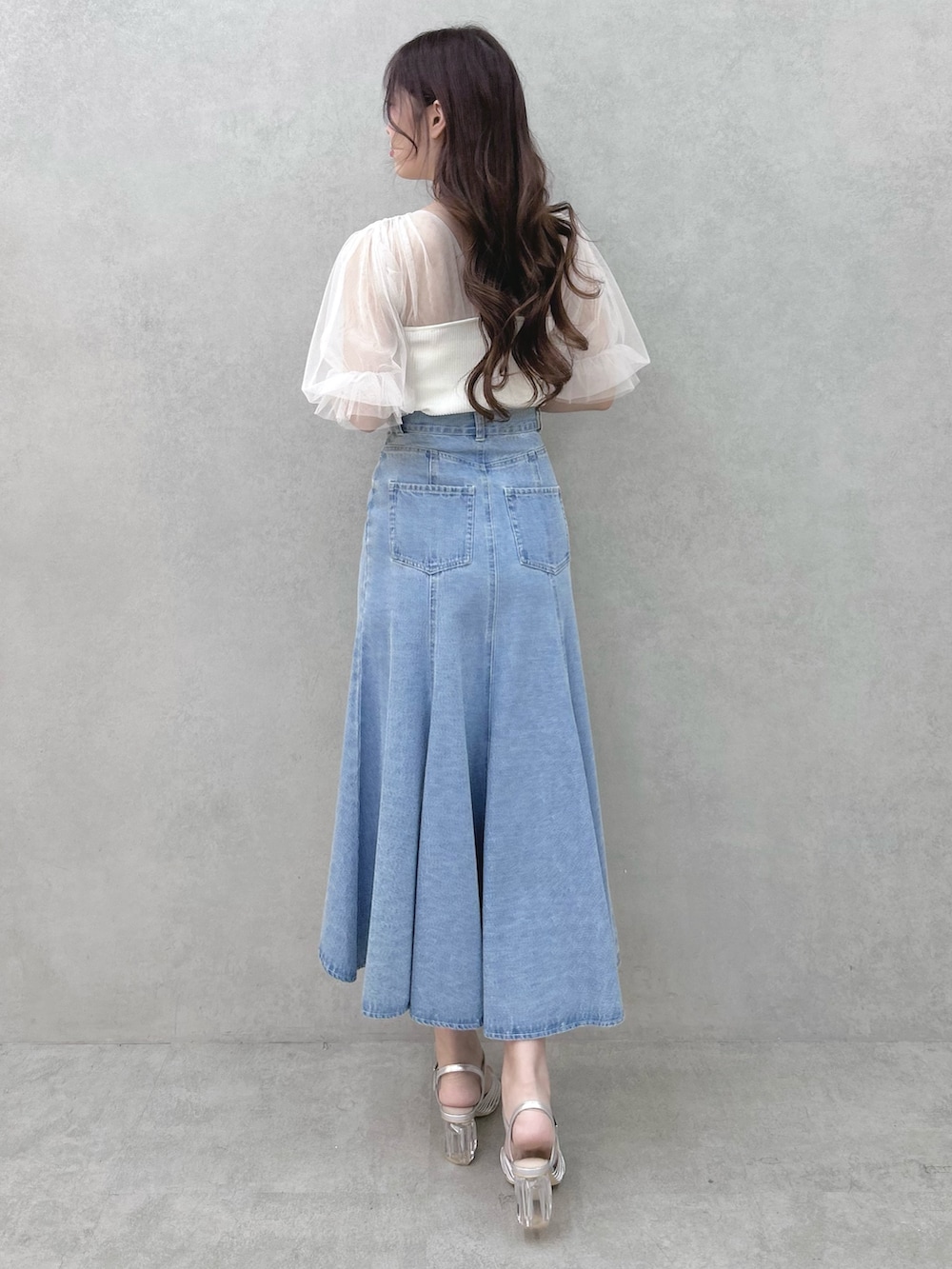 ホワイト系のニット/セーター、ブルー系のスカート、シルバー系のサンダルを着用したレディースの春コーディネートの3枚目の写真