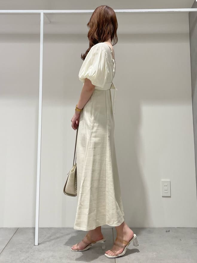 ベージュ系のサンダル、ベージュ系のトートバッグ、ホワイト系のワンピースを着用したレディースの春コーディネートの2枚目の写真