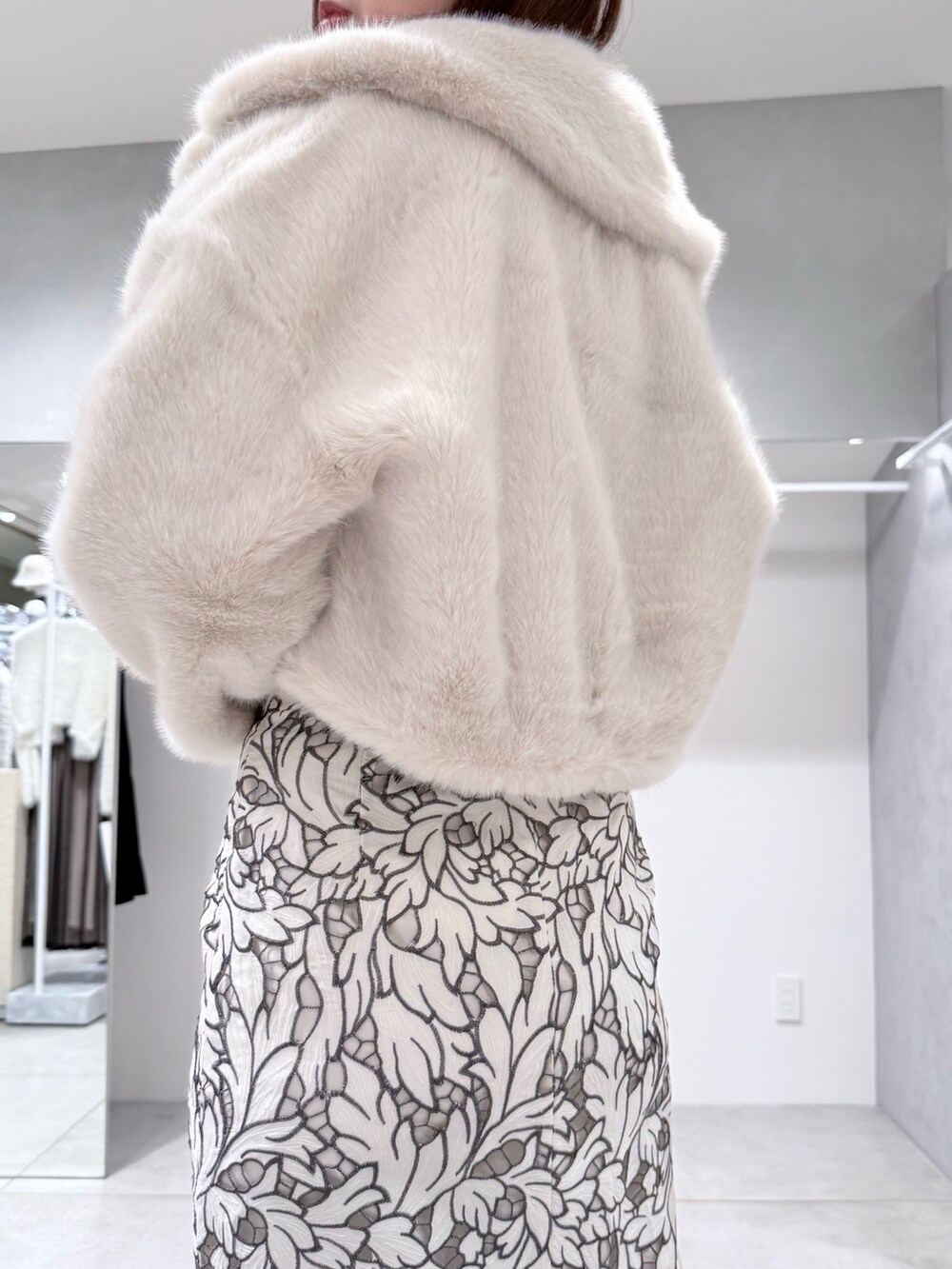 ホワイト系のその他アウター、ブラック系のブーツ、ホワイト系のハンドバッグを着用したレディースの冬コーディネートの6枚目の写真