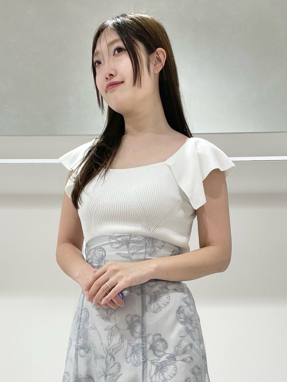 ホワイト系のニット/セーター、ブルー系のスカート、その他のサンダルを着用したレディースの春コーディネートの5枚目の写真