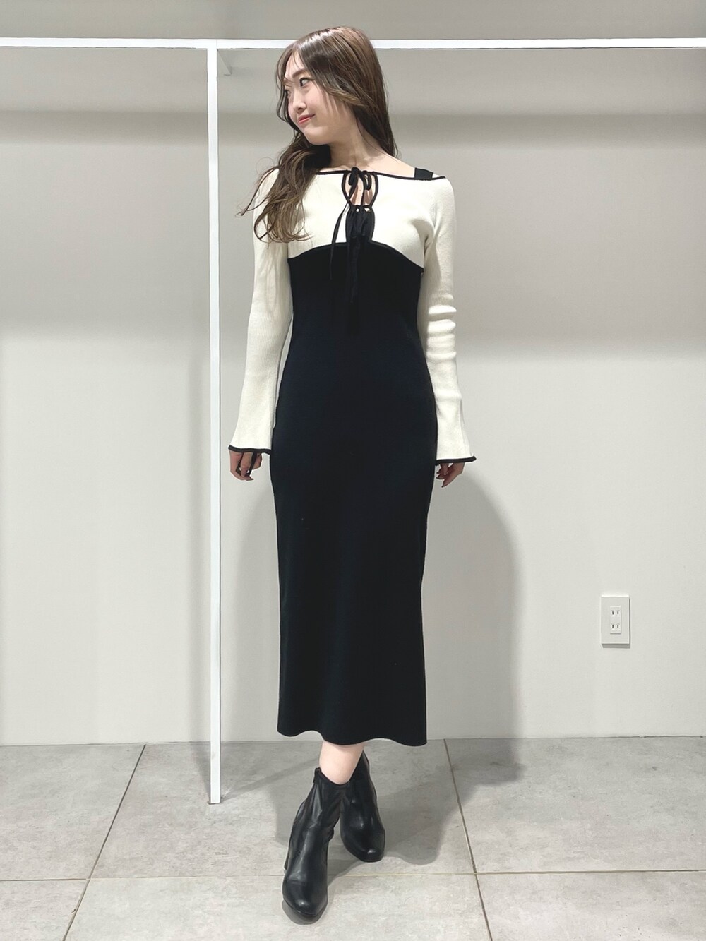 ブラック系のワンピース、ブラック系のブーツを着用したレディースの冬コーディネートの2枚目の写真