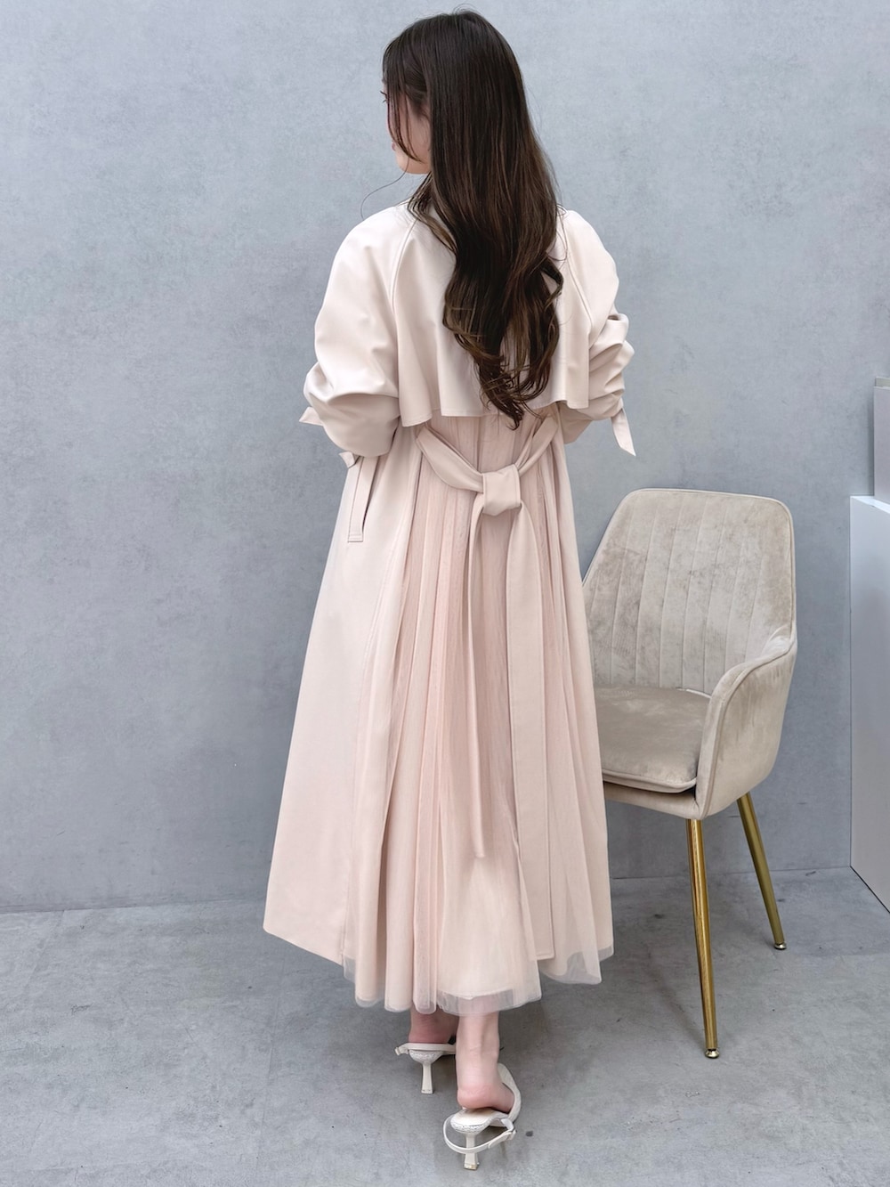 ホワイト系のワンピース、ピンク系のトレンチコート、ホワイト系のパンプスを着用したレディースの冬コーディネートの3枚目の写真