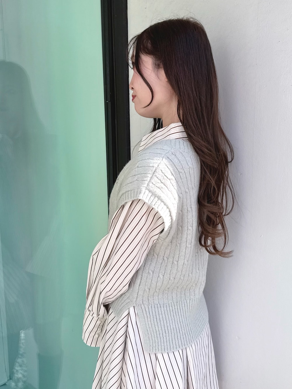 ブラック系のブーツ、グリーン系のワンピースを着用したレディースの冬コーディネートの5枚目の写真