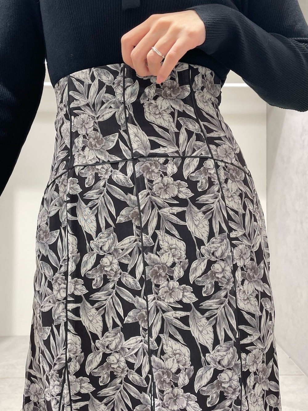 ベージュ系のチェスターコート、ブラック系のブーツ、ブラック系のスカートを着用したレディースの冬コーディネートの9枚目の写真