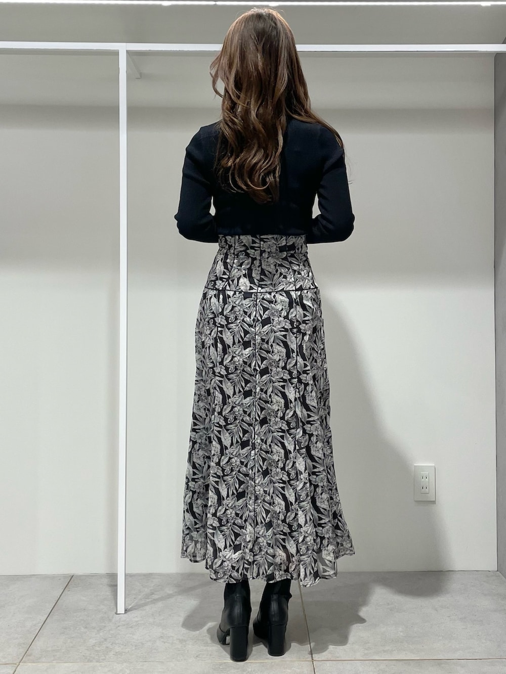 ベージュ系のチェスターコート、ブラック系のブーツ、ブラック系のスカートを着用したレディースの冬コーディネートの6枚目の写真