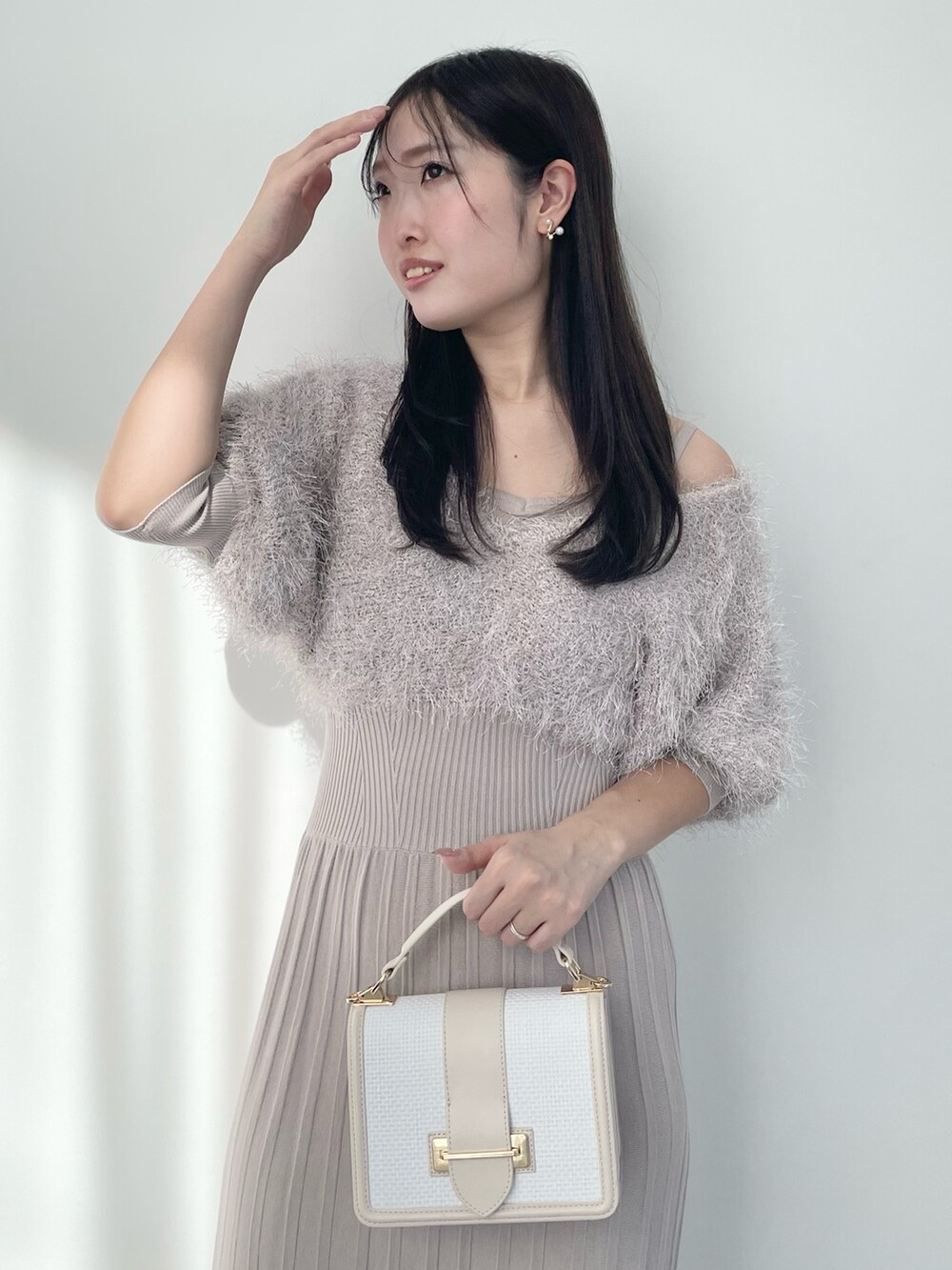 ベージュ系のワンピース、ホワイト系のハンドバッグ、ホワイト系のブーツを着用したレディースの春コーディネートの4枚目の写真