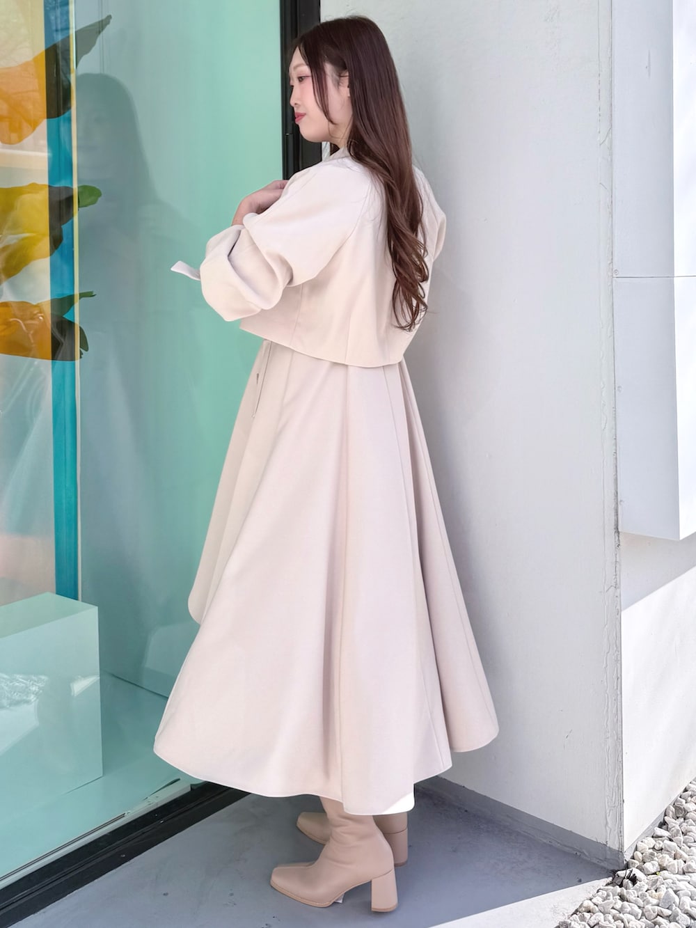 ベージュ系のワンピース、ベージュ系のブーツ、ベージュ系のトレンチコートを着用したレディースの冬コーディネートの2枚目の写真