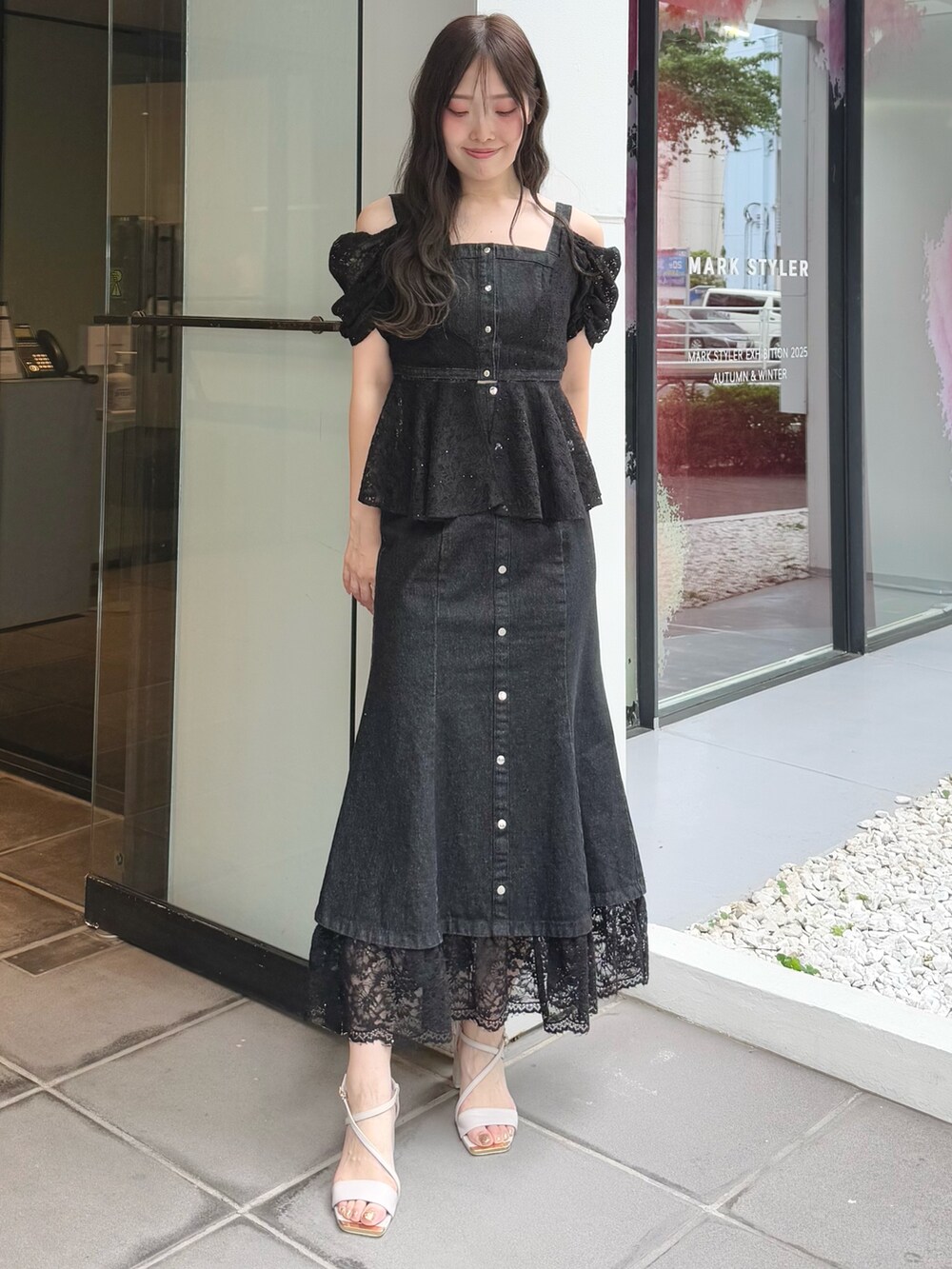 ブラック系のシャツ/ブラウス、ブラック系のスカート、ベージュ系のサンダルを着用したレディースの夏コーディネートの2枚目の写真