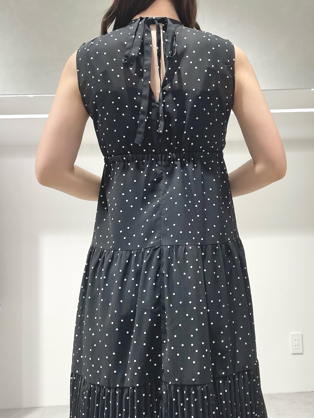 ブラック系のワンピース、ブラック系のサンダルを着用したレディースの夏コーディネートの6枚目の写真