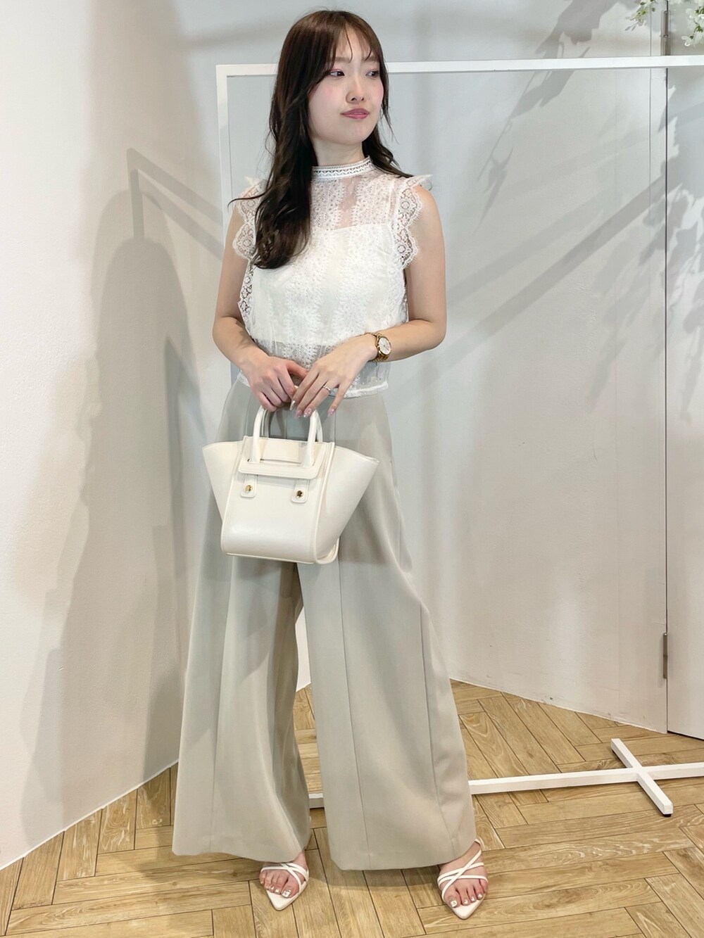 ホワイト系のトートバッグ、ホワイト系のサンダル、グリーン系のその他パンツを着用したレディースの夏コーディネートの3枚目の写真