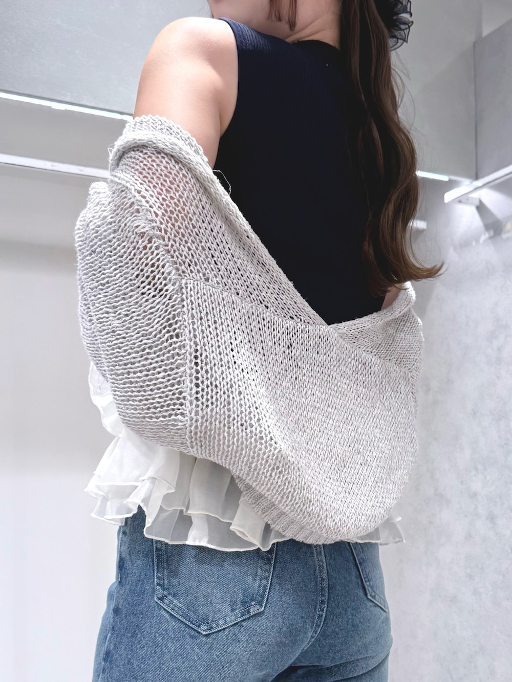 ブルー系のニット/セーター、グレー系のカーディガン/ボレロ、ブルー系のデニムパンツを着用したレディースの夏コーディネートの5枚目の写真
