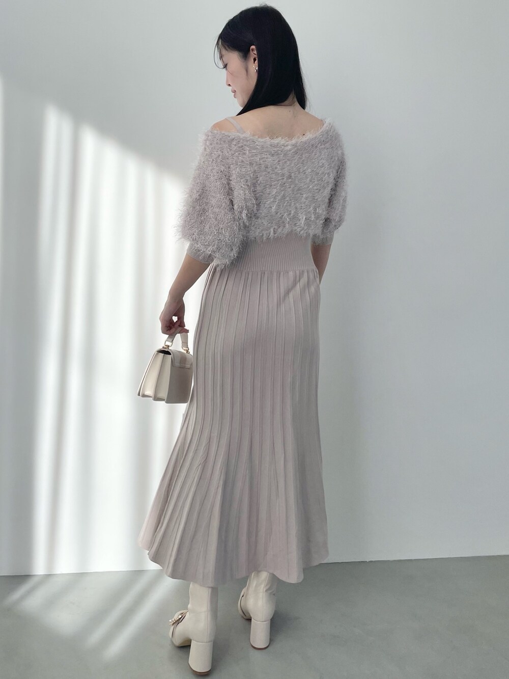 ベージュ系のワンピース、ホワイト系のハンドバッグ、ホワイト系のブーツを着用したレディースの春コーディネートの3枚目の写真