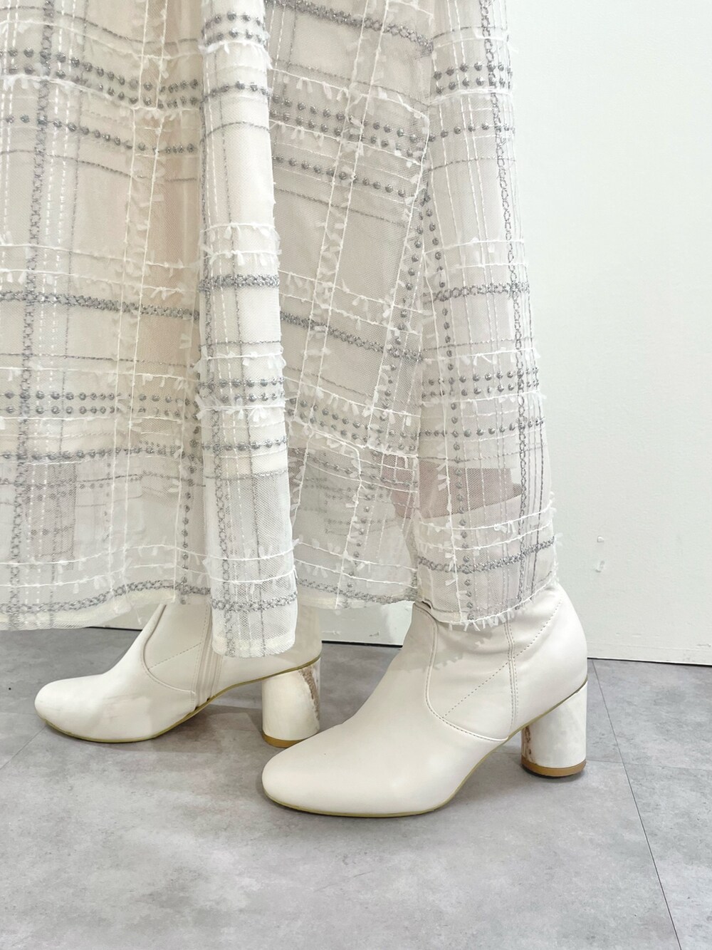 ホワイト系のその他アウター、ホワイト系のスカート、ホワイト系のブーツを着用したレディースの冬コーディネートの9枚目の写真