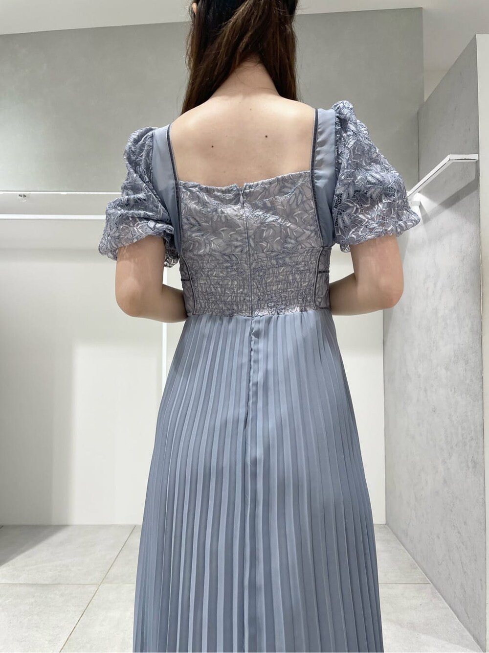 ブラック系のパンプス、ブルー系のワンピース、シルバー系のイヤリングを着用したレディースの秋コーディネートの7枚目の写真