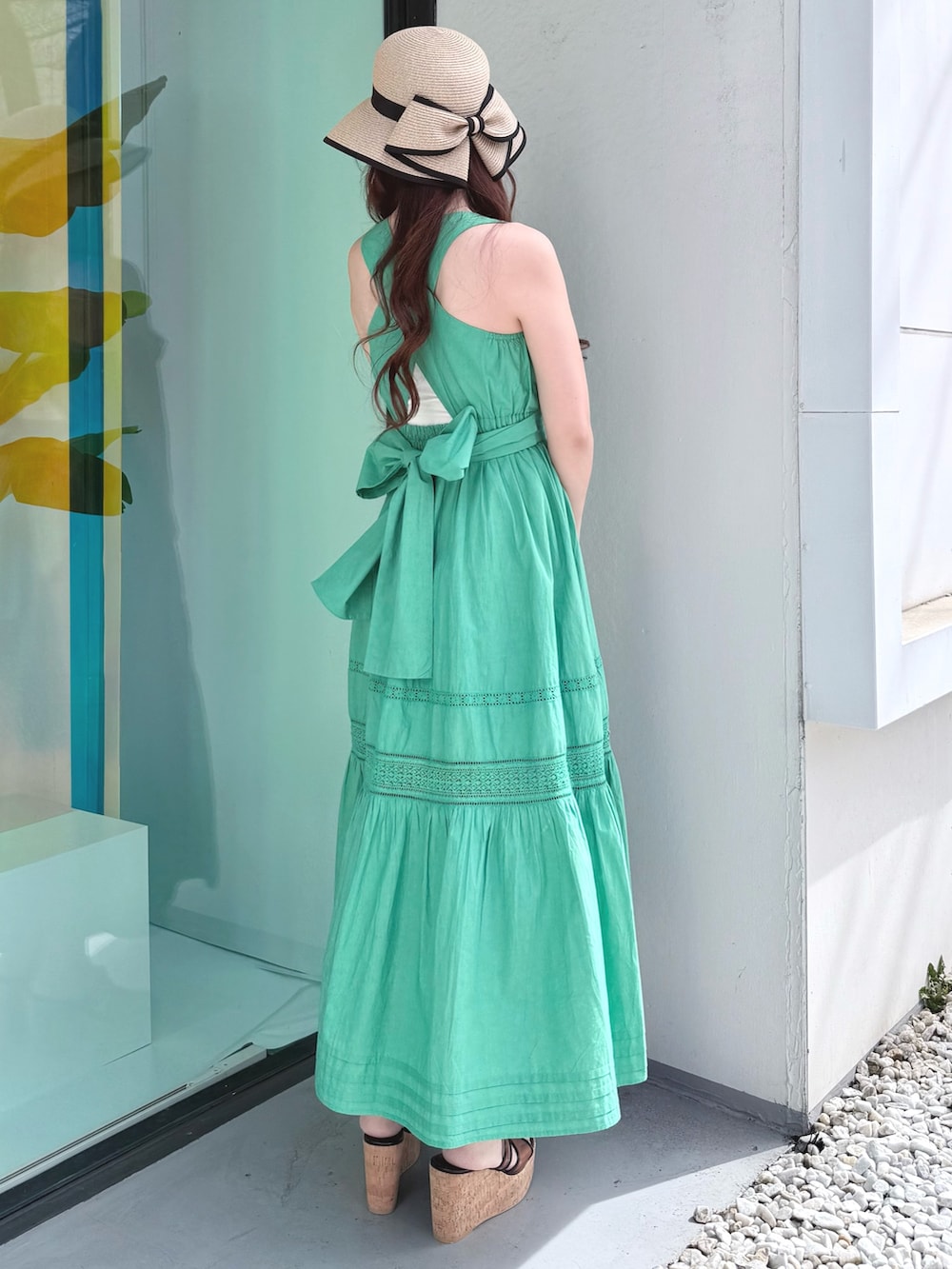 グリーン系のワンピース、ブラウン系のサンダル、ベージュ系のその他雑貨を着用したレディースの春コーディネートの4枚目の写真