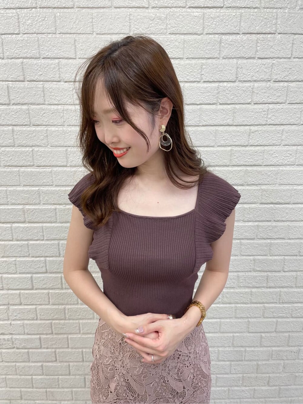 ベージュ系のスカート、ベージュ系のサンダル、ブラウン系のニット/セーターを着用したレディースの夏コーディネートの2枚目の写真