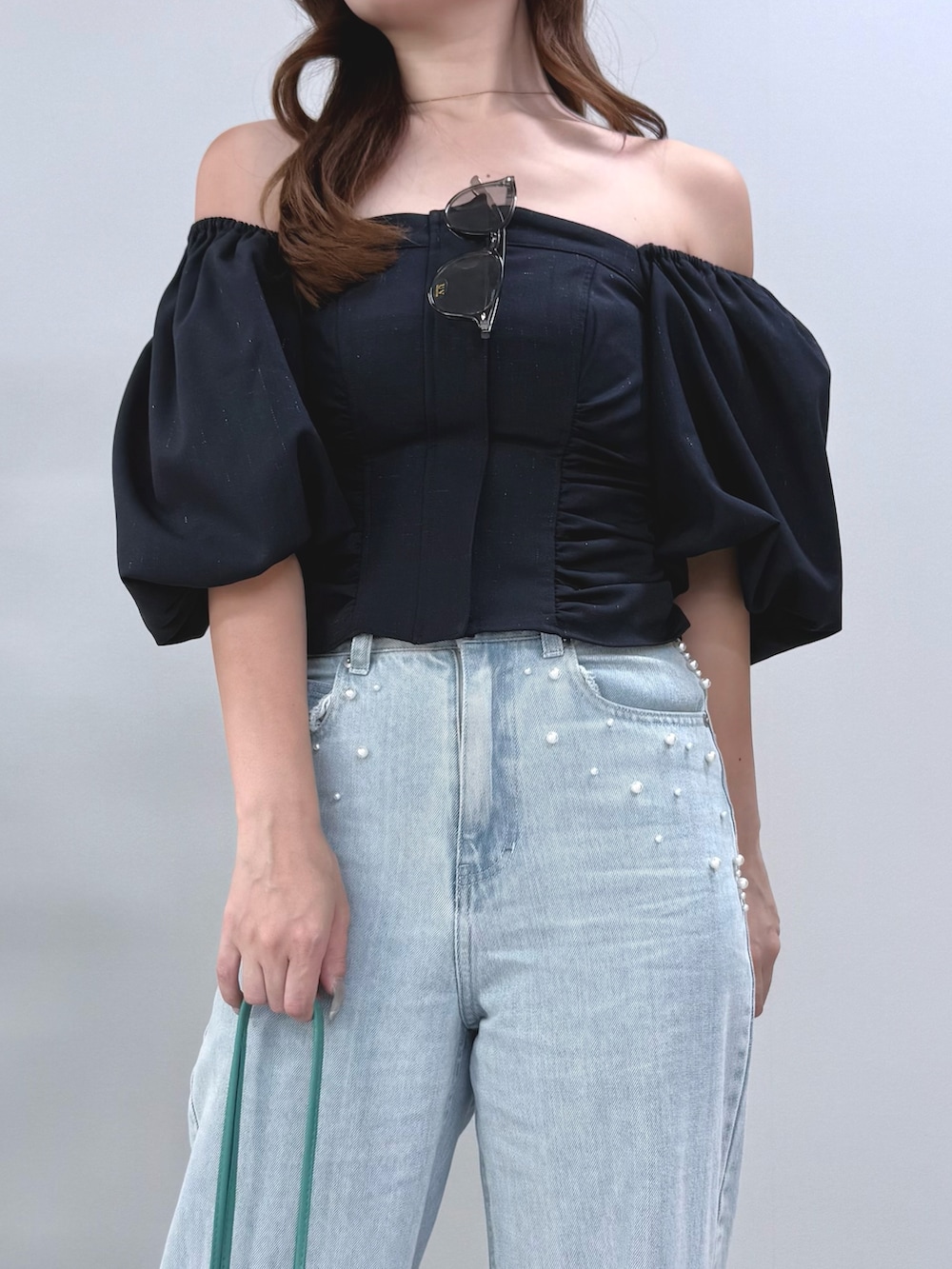 ブルー系のデニムパンツ、グリーン系のショルダーバッグ、ブラック系のサンダルを着用したレディースの夏コーディネートの5枚目の写真